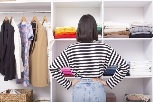 クローゼットの前で悩む女性の画像